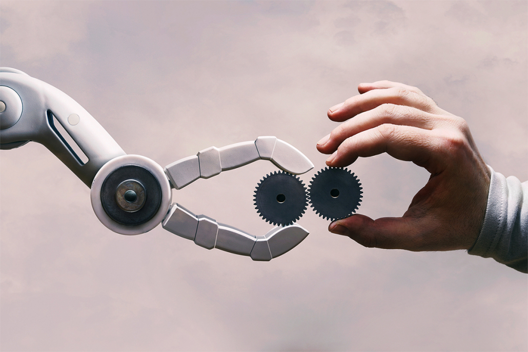 Arm eines Roboters und menschlicher Arm, die zweiZahnräder einanderhalten. Symbolisiert Mensch  und mobilen Roboter in einer Arbeitsumgebung.