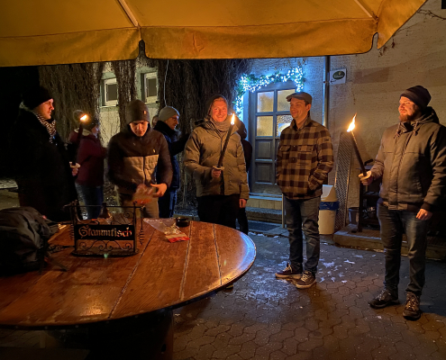 Anzünden der Fackeln für den Rückweg im Dunkeln Anzünden der Fackeln vor dem Wirtshaus Silberwald in Neu-Ulm für den Heimweg durch den Wald an der Iller entlang.