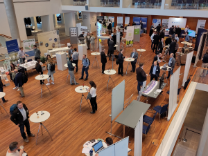 Blick von oben auf den Marktplatz mit Ausstellern aus Industrie und Forschung im Foyer des Konzerthauses in Freiburg.