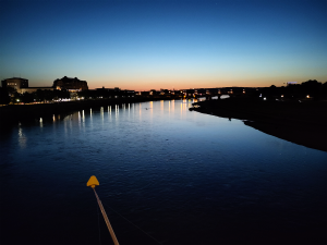 Das Bild zeigt die Elbe in Dresden am späten Abend. Am Hotizont ist noch ein kleines Stück des Sonnenuntergangs zu sehen.